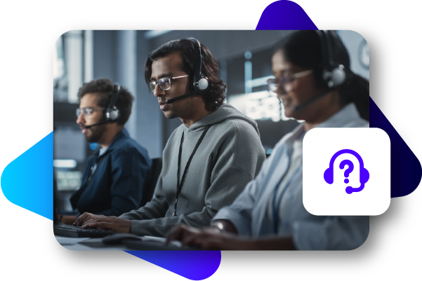 Three people wearing headphones sit at computers in a dimly lit room.
