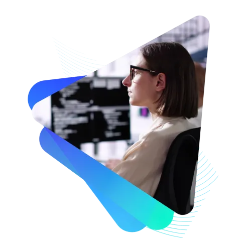 A technologist with glasses using a computer with a monitor of code. The frame is made up of triangles with rounded edges and a cool color palette.
